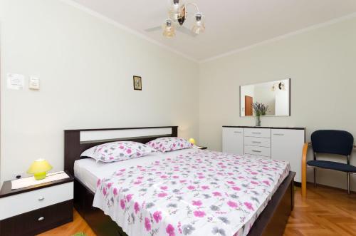 a bedroom with a bed and a desk and a chair at Apartment Neda in Punat