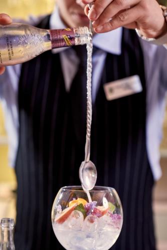 a person holding a spoon over a bowl of food at Villa di Piazzano - Small Luxury Hotels of the World in Cortona
