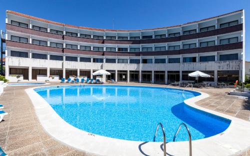 a swimming pool in front of a building at Hotel Meia Lua in Ovar