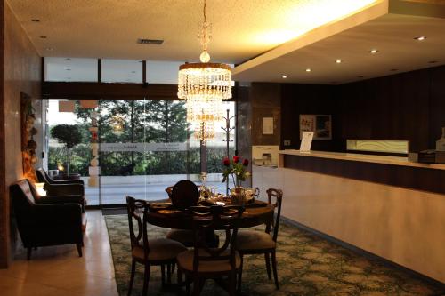 a dining room with a table and a kitchen at Hotel Meia Lua in Ovar