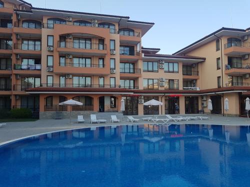 a hotel with a swimming pool in front of a building at Private Apartment in Star Dreams Complex in Sveti Vlas