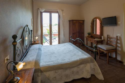 a bedroom with a bed and a chair and a window at I Frutteti "affitta camere" in Lido di Camaiore