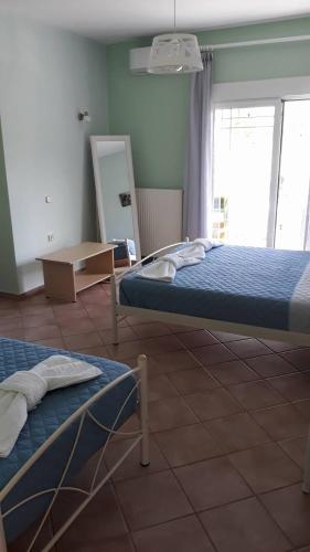 a bedroom with two beds and a mirror in it at Olympic View Guesthouse in Kalami