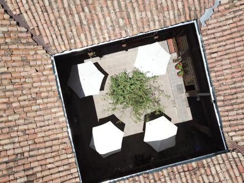 an overhead view of a patio with white umbrellas and a plant at Hostal Qorichaska in Cusco