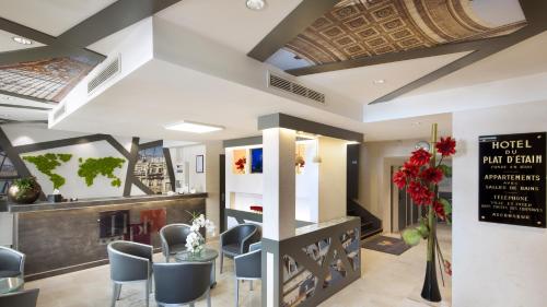 un hall avec une table et des chaises dans un bâtiment dans l'établissement Hôtel du Plat d'Etain, à Paris