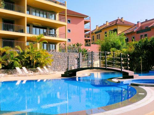 a bridge over a swimming pool in front of a building at Luxury Apartment Living Funchal in Funchal