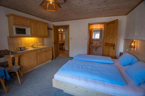 a bedroom with a large bed and a kitchen at Landhaus KATRIN in Holzgau