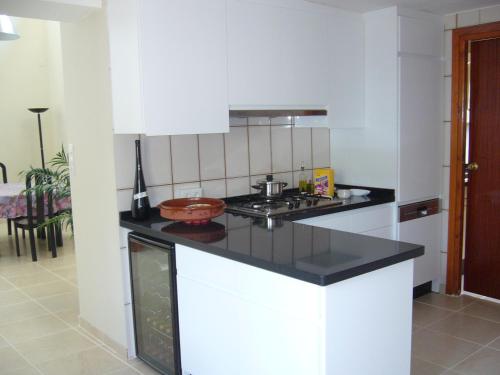a kitchen with white cabinets and a black counter top at B&B Lasnavillasmm in Montefrío