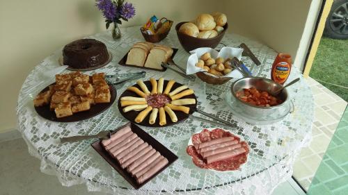 een tafel met een tafelkleed met voedsel erop bij Pousada Alelo in Guarujá