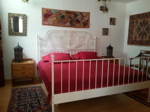 Schlafzimmer mit einem weißen Bett und roten Kissen in der Unterkunft Casa Emma in Valle Gran Rey