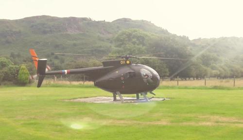 a black helicopter parked in a grass field at Bower House Inn in Eskdale