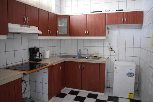 a small kitchen with wooden cabinets and a sink at Alojamiento Verdi, Entre Rios,Guayaquil, Ecuador in Entre Ríos