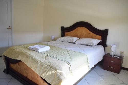 a bedroom with a large bed with two towels on it at Alojamiento Verdi, Entre Rios,Guayaquil, Ecuador in Entre Ríos