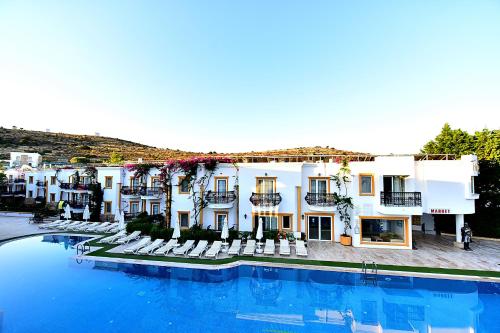 a hotel with a swimming pool in front of a building at Tropicana Beach in Gümbet