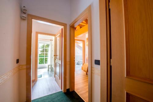 a hallway with an open door to a room at Hotel Villa Rosella Park & Wellness in Canazei
