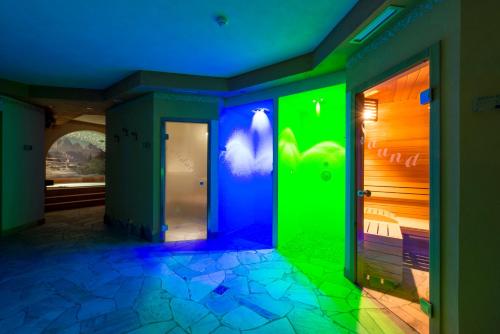a room with green and blue lights on the wall at Hotel Villa Rosella Park & Wellness in Canazei