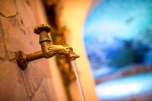 a bronze water faucet attached to a wall at Hotel Villa Rosella Park & Wellness in Canazei