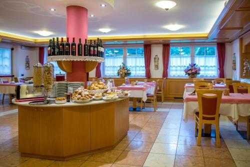 a dining room with a table with food on it at Hotel Villa Rosella Park & Wellness in Canazei
