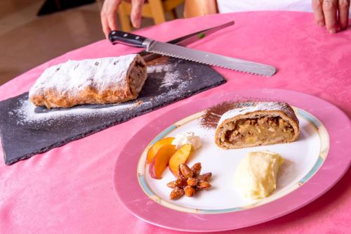 a plate of bread and fruit on a pink table at Hotel Villa Rosella Park & Wellness in Canazei