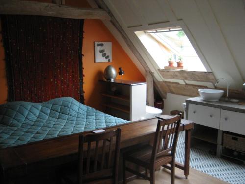 1 dormitorio con 1 cama, mesa y sillas en Chambre du Toucan, en Misy-sur-Yonne