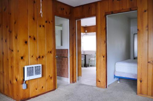 Habitación con paredes de madera y dormitorio con cama. en By the Lake, en Clearlake