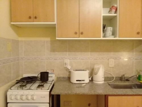 a kitchen with a white stove and a sink at B3 Apartments in Formosa