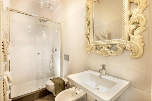 a bathroom with a sink and a toilet and a mirror at Sweet Tuscany Appartamento Gold in Arezzo