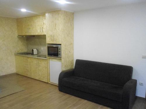 uma sala de estar com um sofá e uma cozinha em Campismo Rural Rio Caldo Geres no Gerês