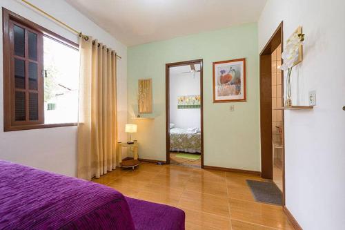 a bedroom with a purple bed and a window at Itaporanga Pousada in Santa Maria Madalena