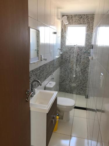 a bathroom with a toilet and a sink and a shower at Mandakaru Residence Flat 10 in Porto De Galinhas