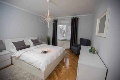 una camera bianca con un letto e un divano di Green Avenue Apartment Zagreb a Zagabria