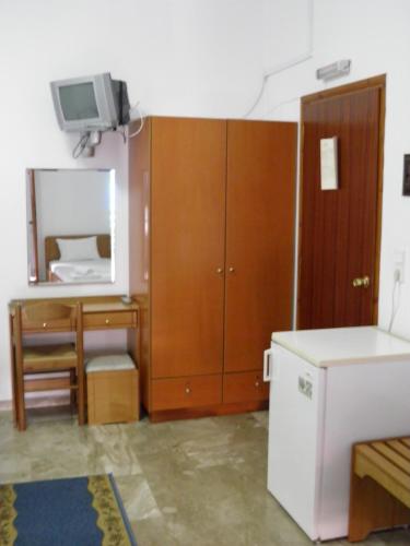 a room with a desk and a tv and a cabinet at Samaria in Agia Roumeli