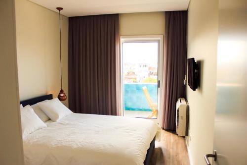 een slaapkamer met een bed en een raam met uitzicht bij Apartamento da Lapa in Porto