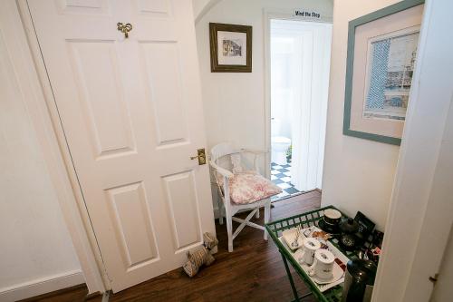 a room with a door and a chair and a table at Southford House (Room Only) in Dartmouth