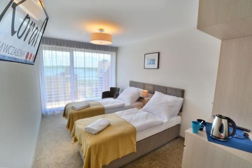 um quarto de hotel com duas camas e uma janela em DW Koral em Niechorze