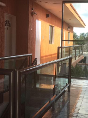 a balcony of a house with a glass railing at Hotel Posada Mercy in Río Lagartos
