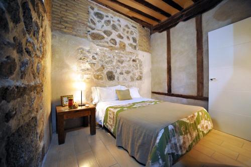 1 dormitorio con 1 cama y 1 mesa con lámpara en King David Suite, en Toledo