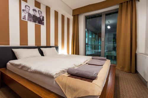 a bedroom with a large bed with a wooden platform at City Heart Wellness Apartment in Budapest