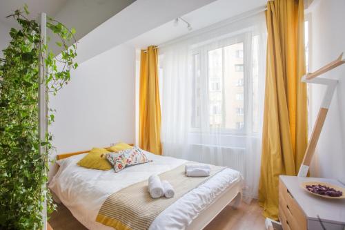 Habitación pequeña con cama y ventana en Central Garden by CityLife Suites, en Bucarest