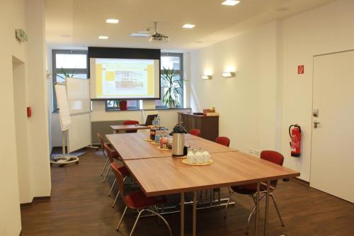 a conference room with a large wooden table and chairs at Hostel Köln in Cologne