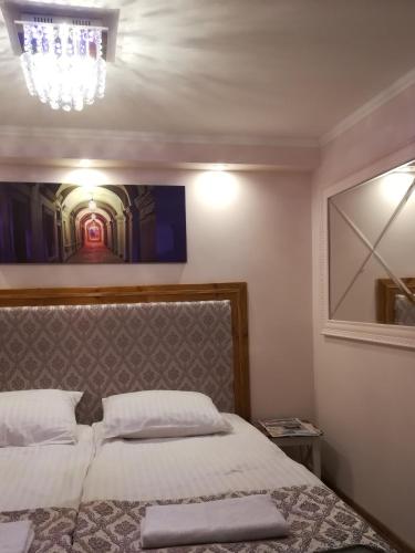 a bedroom with a bed and a chandelier at Apartament Akademicka in Zamość
