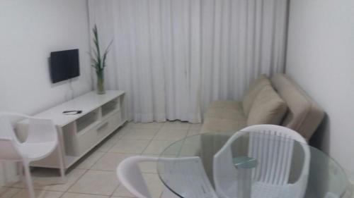 a living room with a glass table and a couch at Flats Jaqueira Prime in Recife