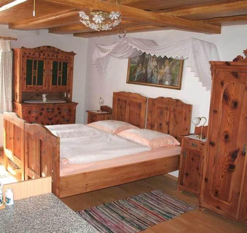 sypialnia z dużym drewnianym łóżkiem i drewnianymi szafkami w obiekcie Kanzlerhof w mieście Bad Mitterndorf