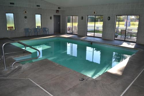 a swimming pool with green water in a building at Sky Lodge Inn & Suites - Delavan in Delavan