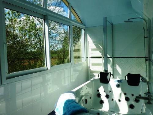 a bathroom with a tub and a window and a sink at gites de rêve en Finistère in Quéménéven