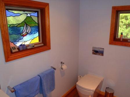 a bathroom with a toilet and a stained glass window at The Tree House in Alonnah