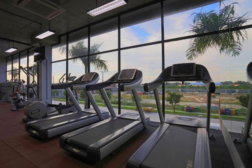 a gym with several treadmills in front of a large window at Eco Garden Residences in Phnom Penh