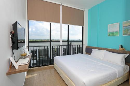 a bedroom with a large bed and a large window at Eco Garden Residences in Phnom Penh