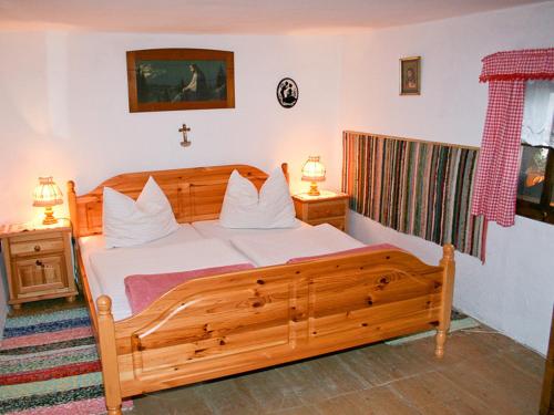 ein Schlafzimmer mit einem Holzbett mit weißen Kissen in der Unterkunft Ferienhaus Nelln in Reith