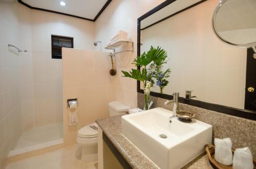 y baño con lavabo, aseo y espejo. en Sea Wind Resort, en Boracay
